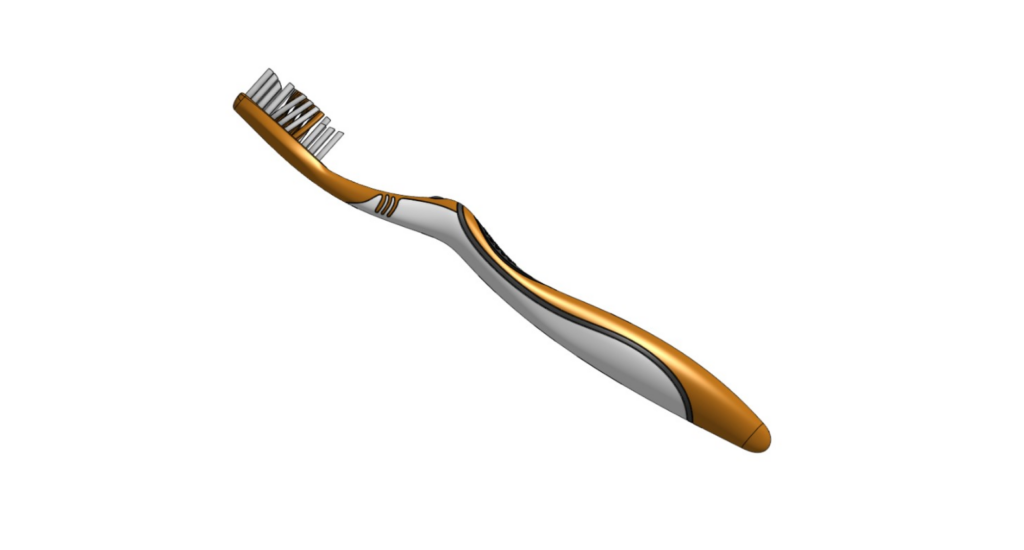 A gold and silver toothbrush with white and dark bristles sits against a plain white background, its sleek handle subtly echoing the smooth curves of a fillet rather than the sharp edge of a chamfer.