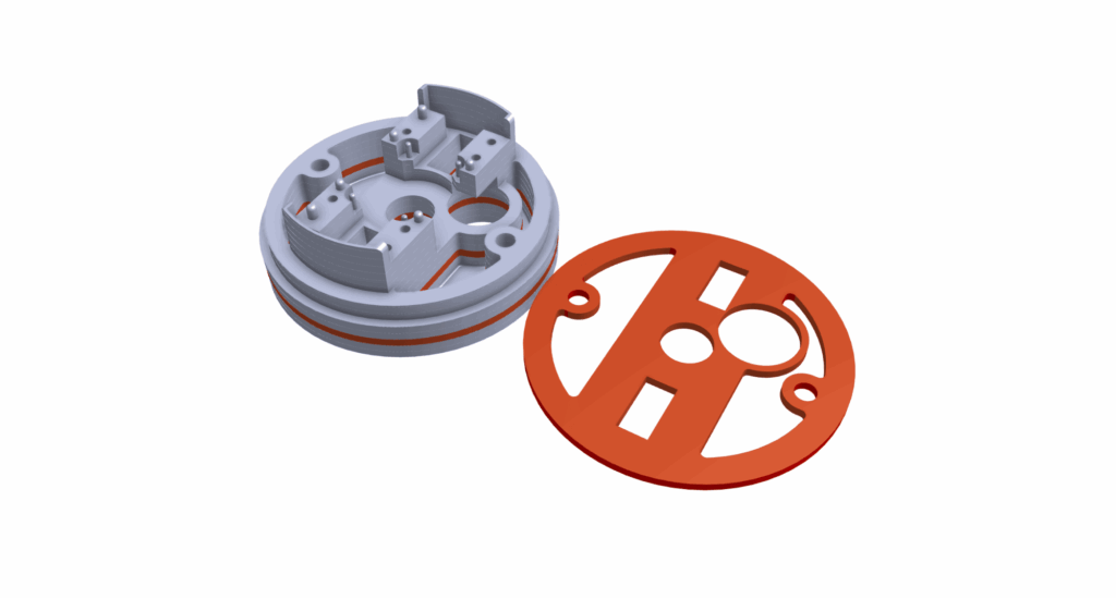 A 3D-rendered mechanical component with a circular grey base, internal structures, and a separated flat orange cover plate, ideal for prototyping injection moldings, shown on a white background.