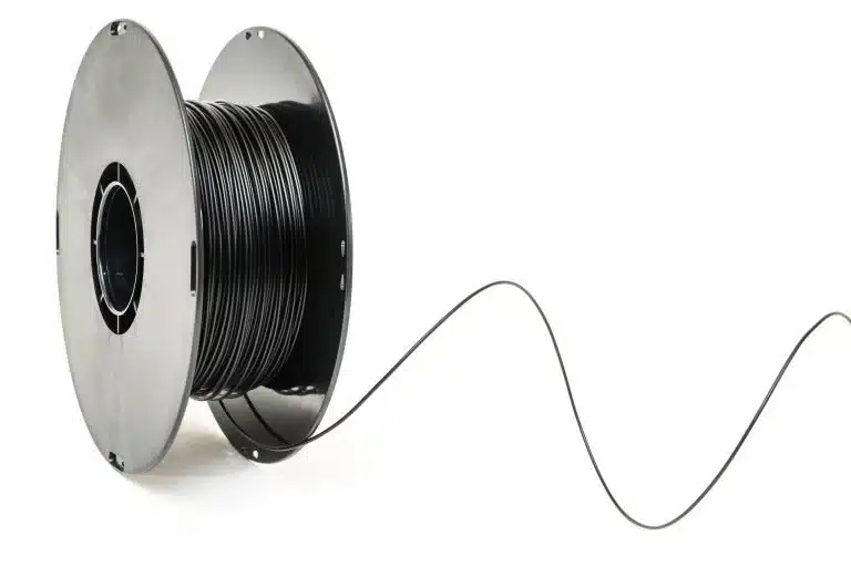 A spool of black 3D printer filament with a strand extending out, set against a white background.