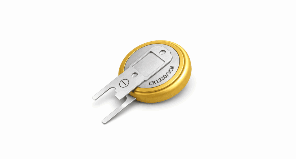 A coin cell battery with metal tabs attached by spot welding, labeled CR2210/VCN, on a white background.