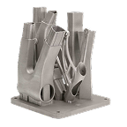 A 3D-printed metal component with complex geometric shapes and support structures, mounted on a flat base plate.