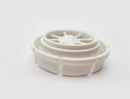 A white plastic wheel, made of durable ABS, with a ridged edge and a central hub lies on a clean white background.
